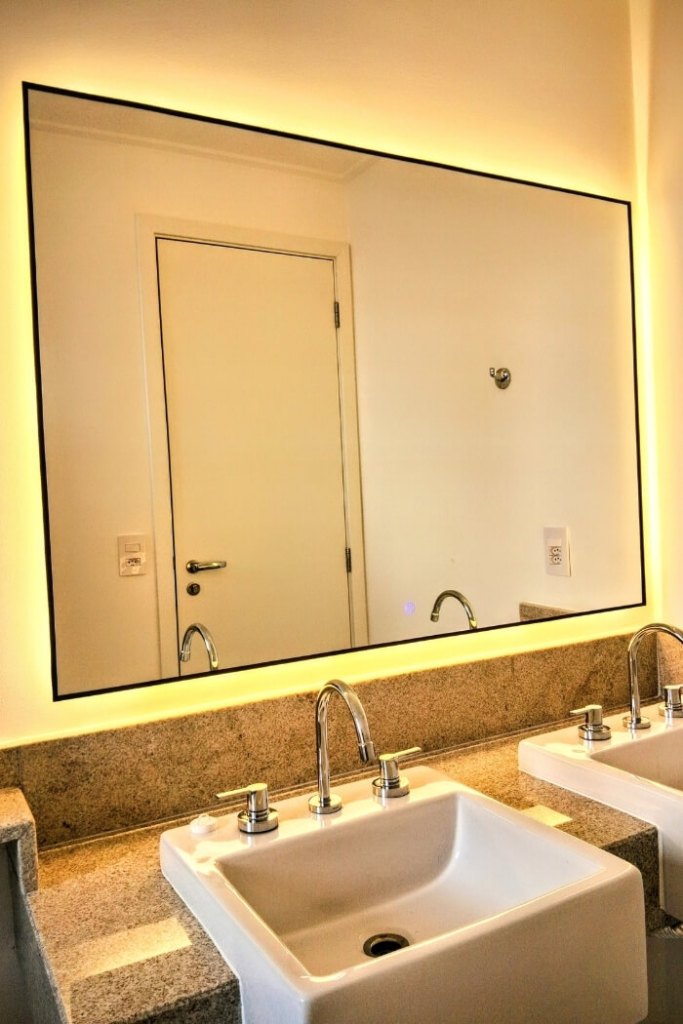 Espelho com LED amarelo retangular e moldura discreta em banheiro moderno com duas cubas em Sorocaba.